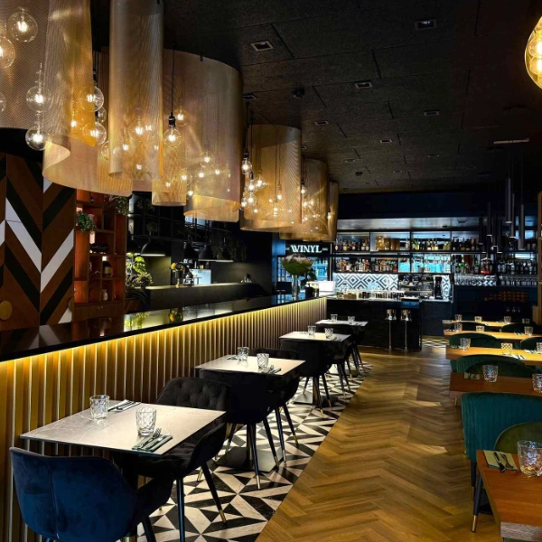 Restaurant WINYL en Estonie : sol Amtico Gatsby Square Small (DC570) sous les tables, associé à un parquet en chevron